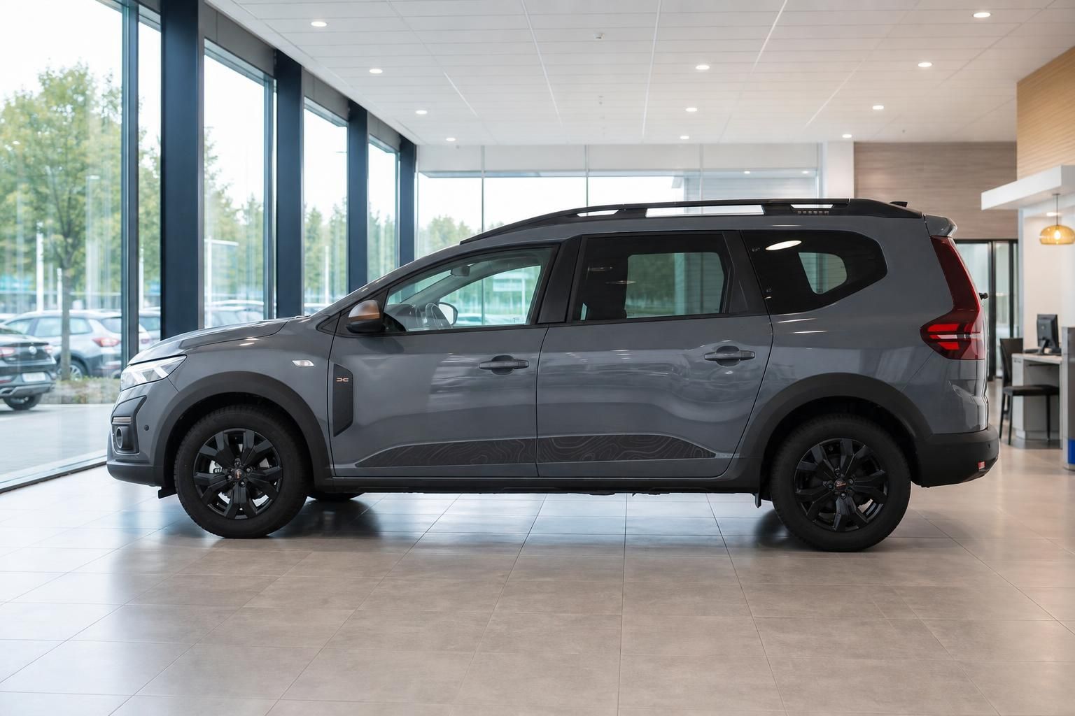 Dacia Jogger grau in Seitenansicht im Autohaus-Showroom