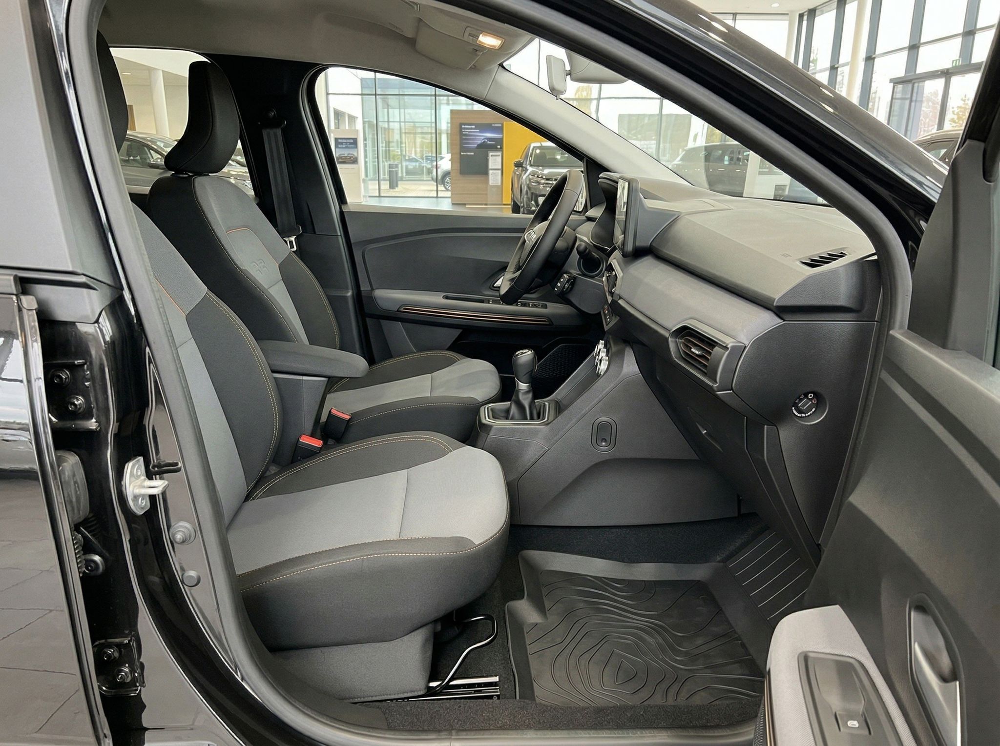 Dacia Beifahrerseite Innenraum mit grauen Sitzen und Mittelkonsole