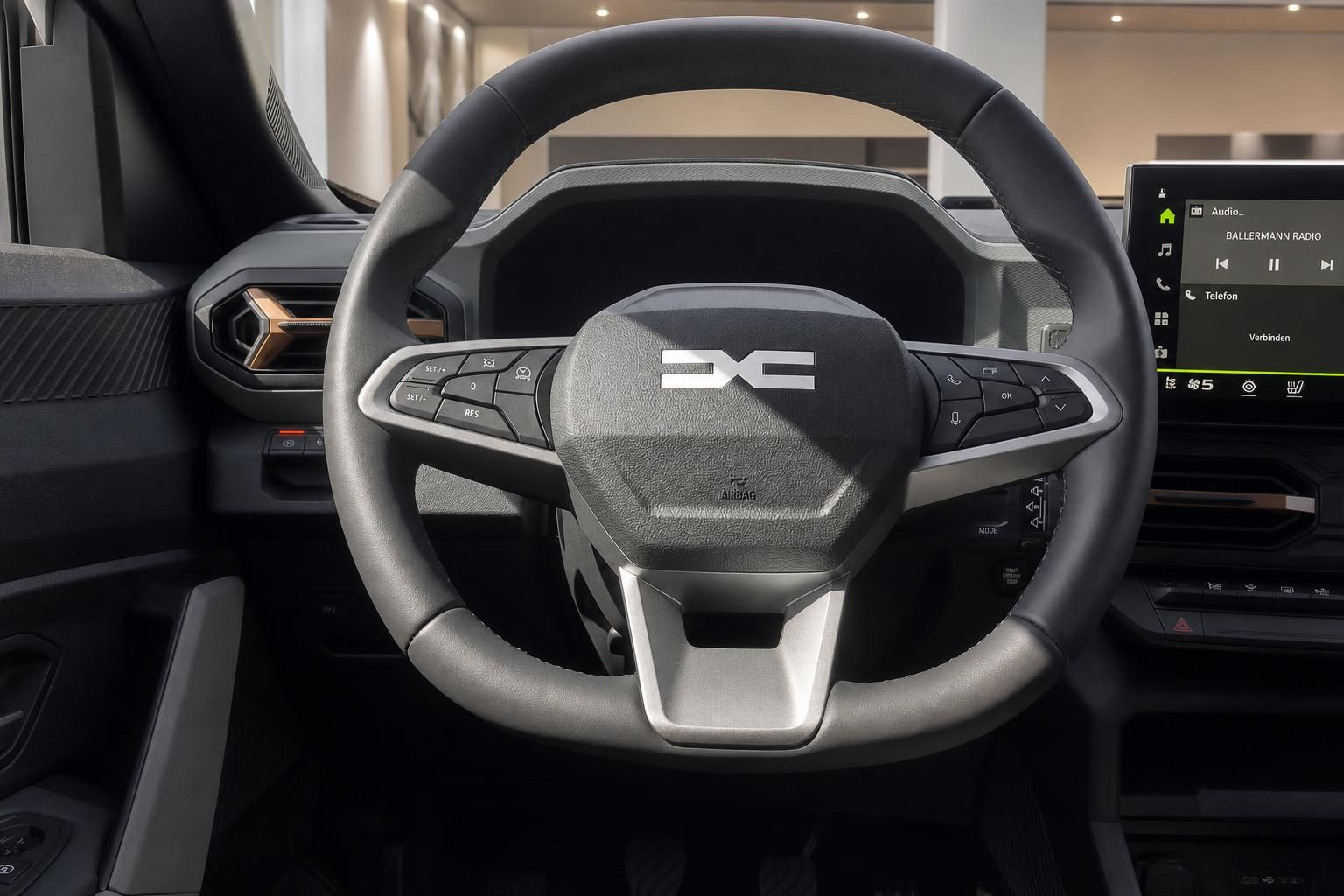 Dacia Innenraum Lenkrad mit Logo und Multifunktionstasten sowie Infotainment-Display