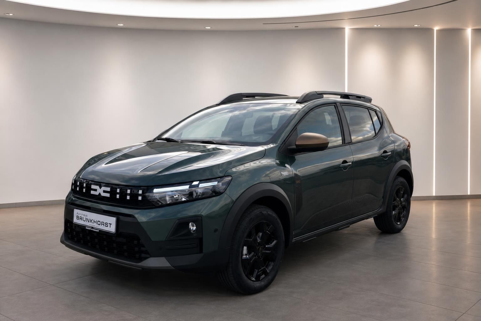 Grüner Dacia Sandero Seitenansicht mit schwarzen Felgen im Autohaus Brunkhorst Showroom