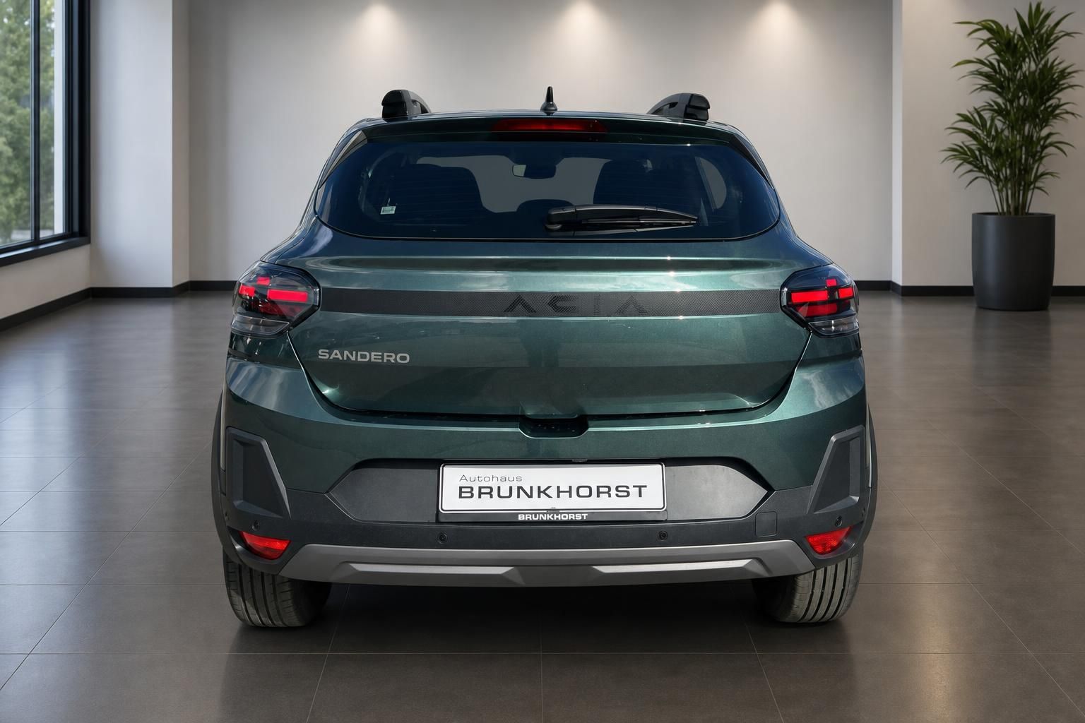 Grüner Dacia Sandero Heckansicht mit LED-Rücklichtern im Autohaus Brunkhorst Showroom