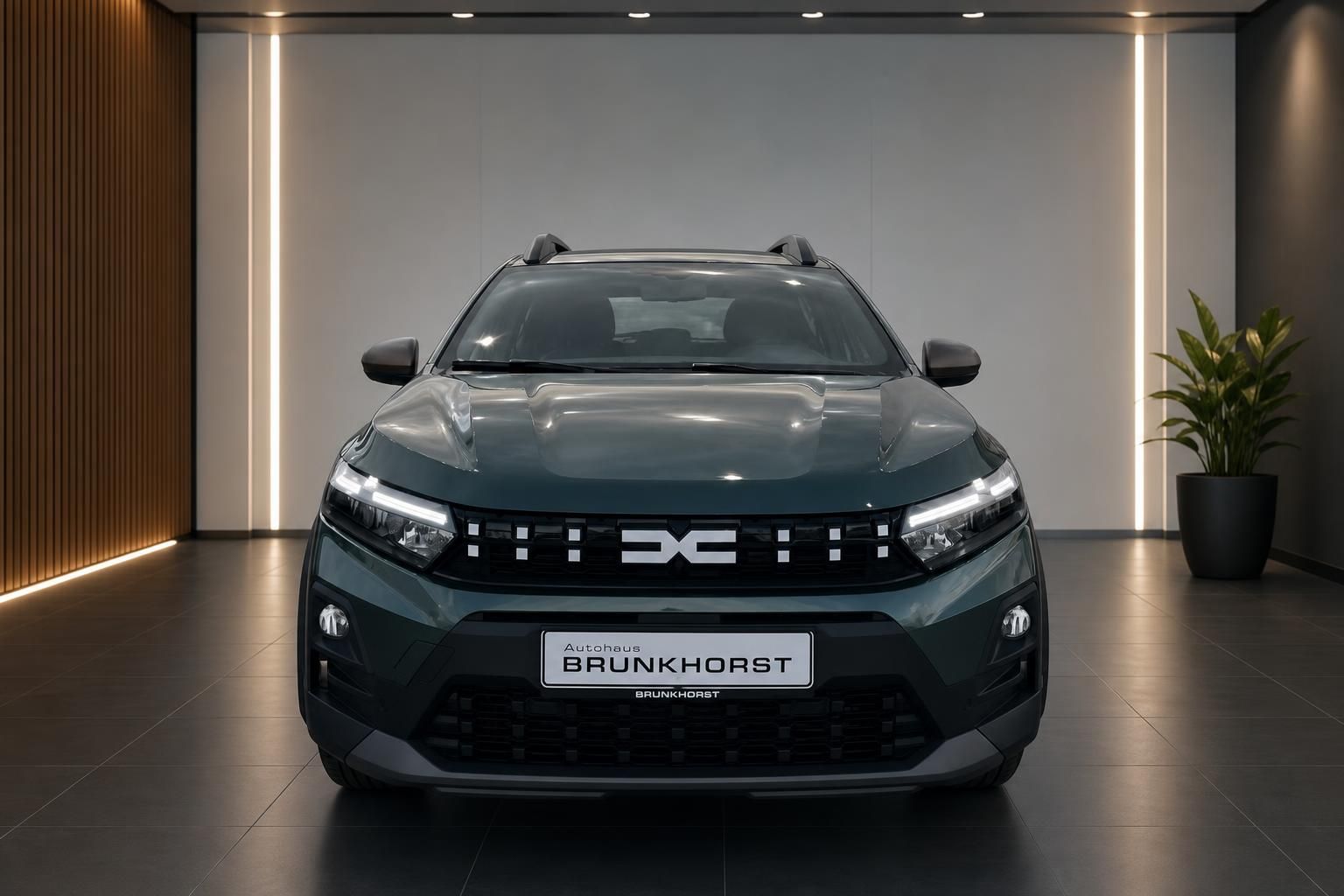 Grüner Dacia Sandero Frontansicht im Autohaus Brunkhorst Showroom mit moderner Beleuchtung