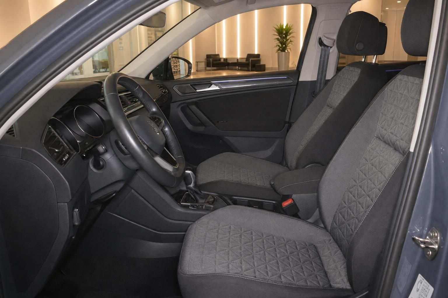 VW Tiguan Innenraum Fahrerseite mit Lenkrad, Schalthebel und grauen Stofssitzen