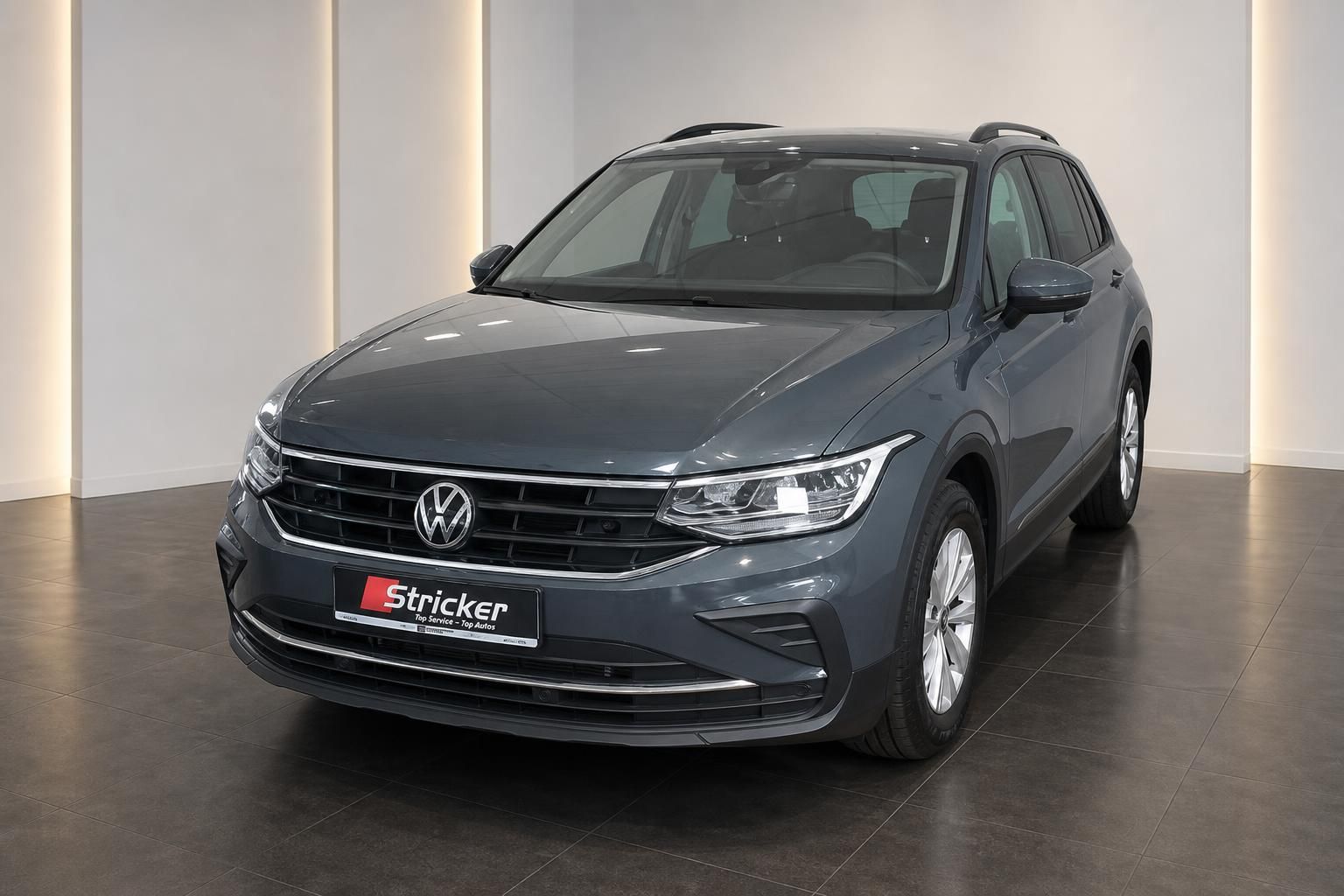 VW Tiguan grau Frontansicht schräg links im Autohaus – SUV Gebrauchtwagen kaufen