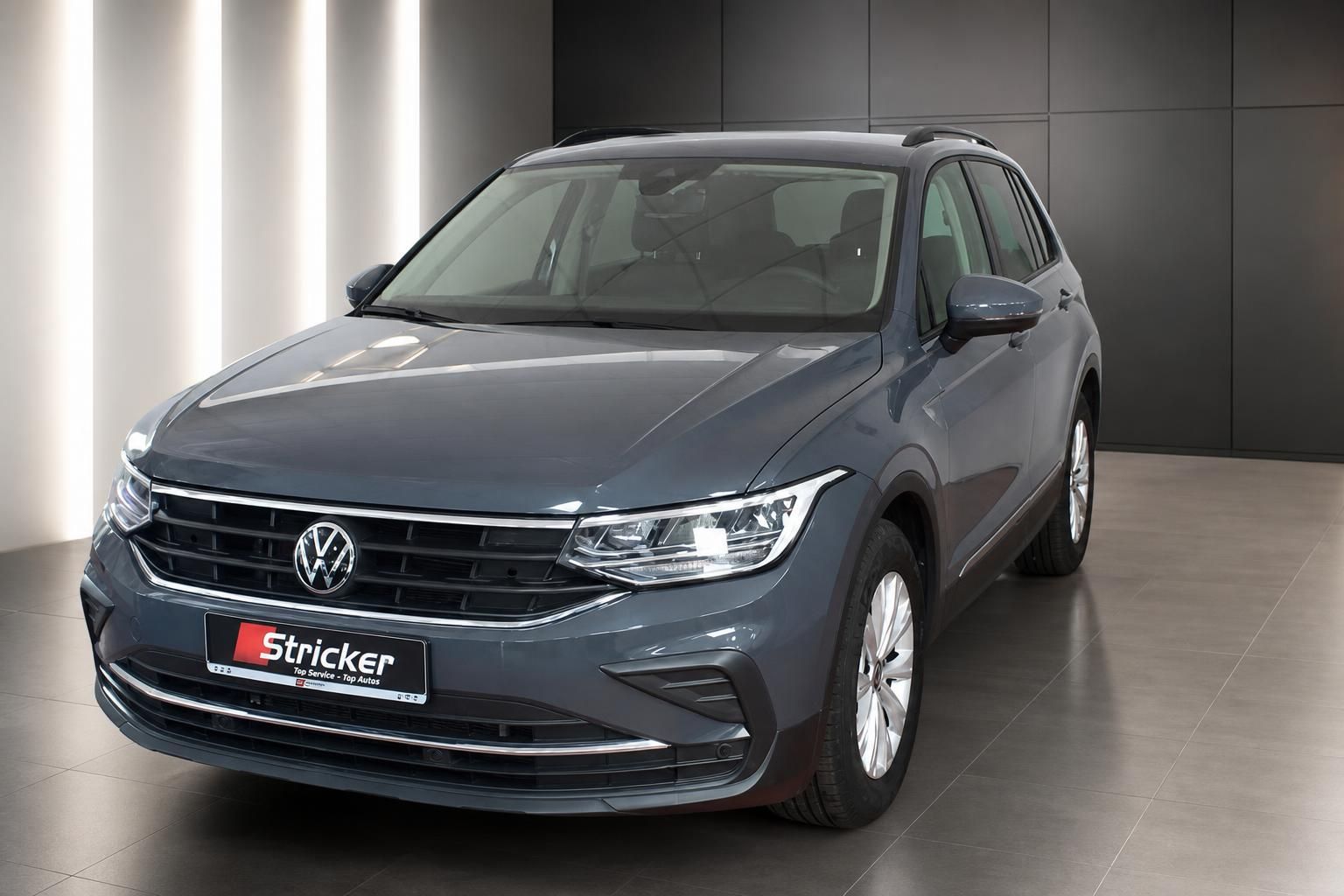 VW Tiguan grau Frontansicht schräg rechts im Showroom – SUV Gebrauchtwagen