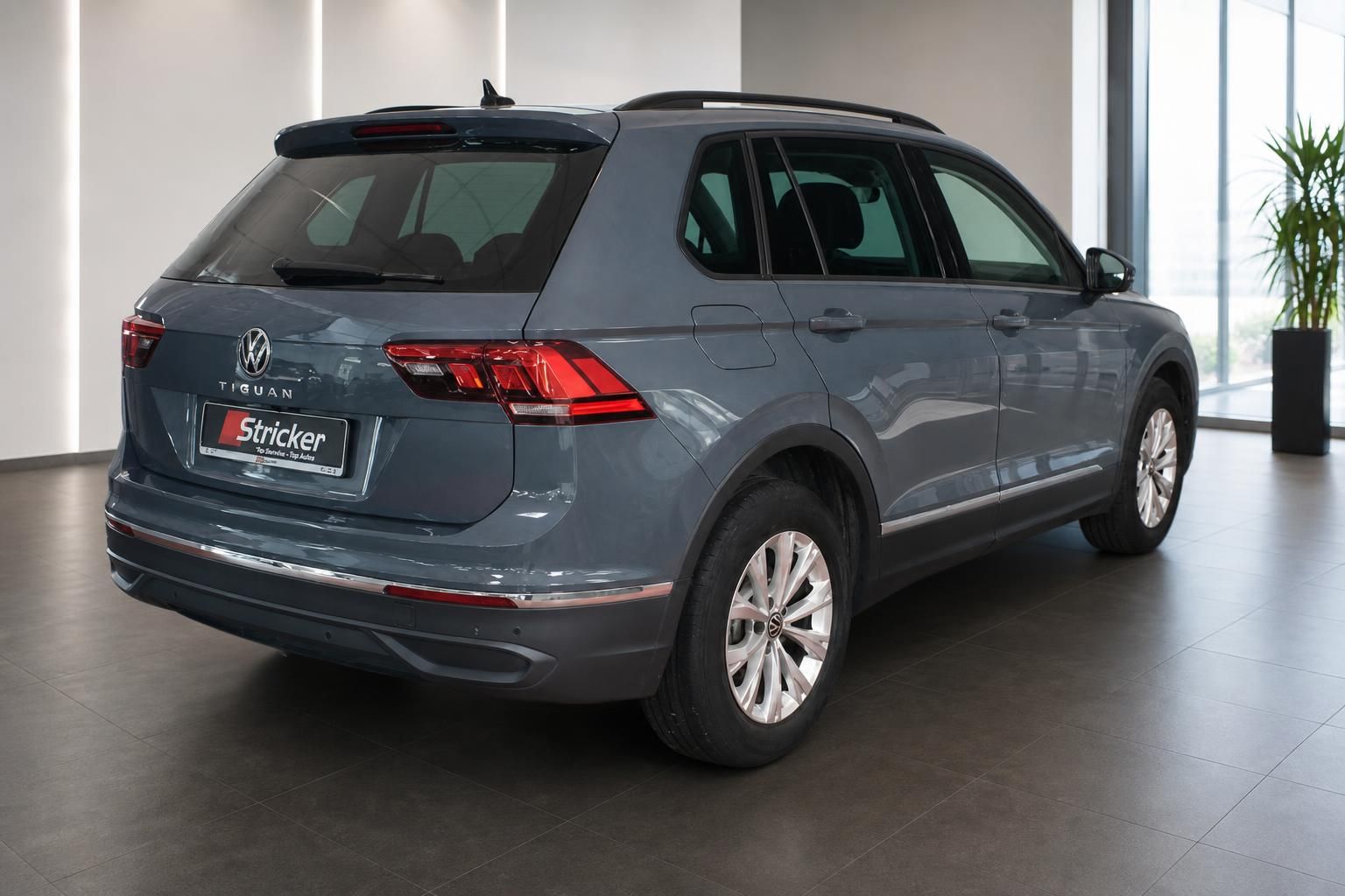 VW Tiguan grau Heckansicht schräg rechts mit LED-Rückleuchten im Autohaus