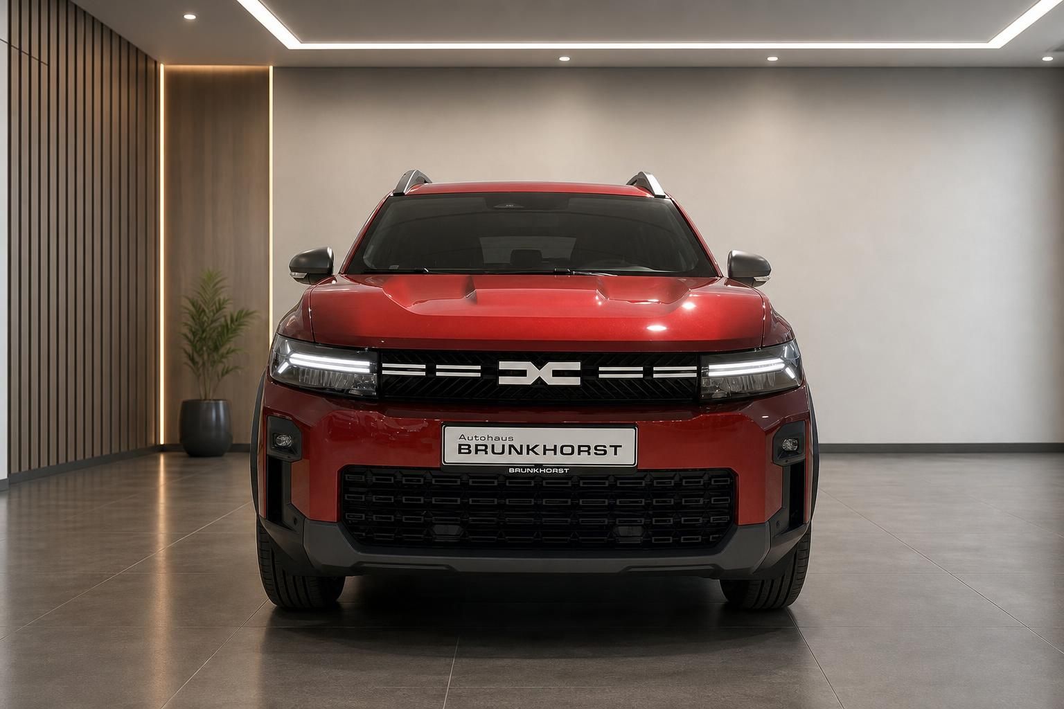 Dacia Bigster Frontansicht in rot mit Autohaus Brunkhorst Kennzeichen im Showroom
