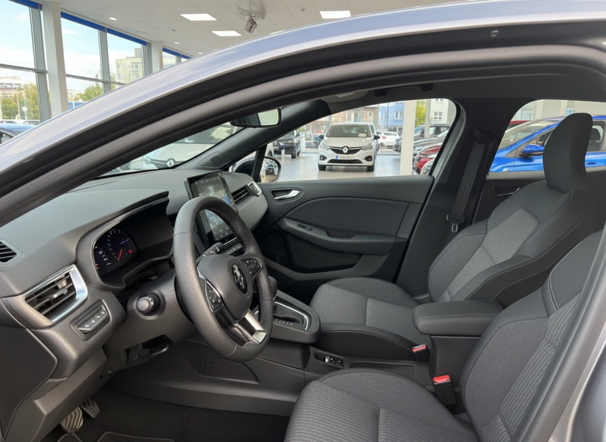 Renault Innenraum mit digitalem Cockpit, Lenkrad und grauen Stoffsitzen im Autohaus