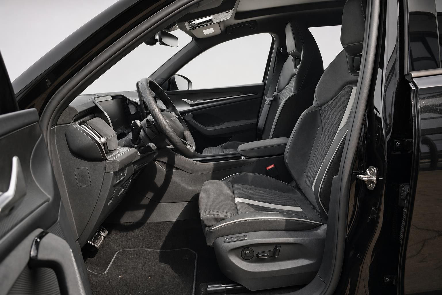 Fahrzeuginnenraum mit schwarzen Sportsitzen und Cockpit, Blick durch offene Tür