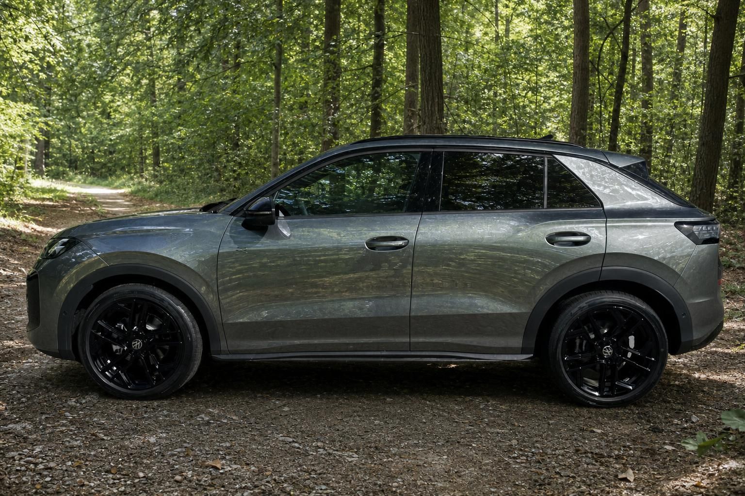 Volkswagen T-Roc grauer SUV Seitenprofil mit schwarzen Sportfelgen im Waldweg