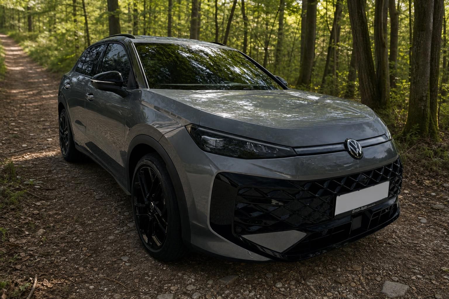 Volkswagen T-Roc grauer SUV Frontansicht mit schwarzen Felgen im Wald