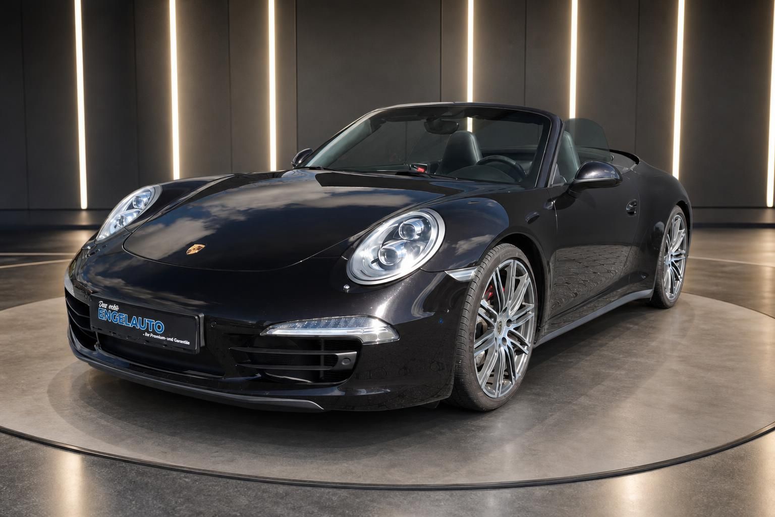 Porsche 911 Cabrio schwarz Dreiviertel-Ansicht mit Seitenprofil in elegantem Showroom