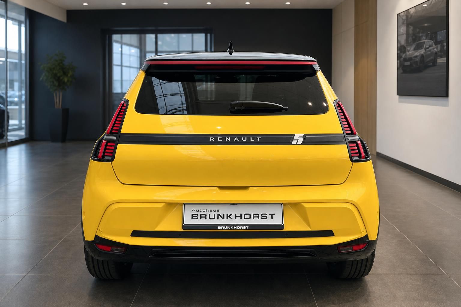 Renault 5 E-Tech Electric gelb Heckansicht mit LED-Rückleuchten im Autohaus