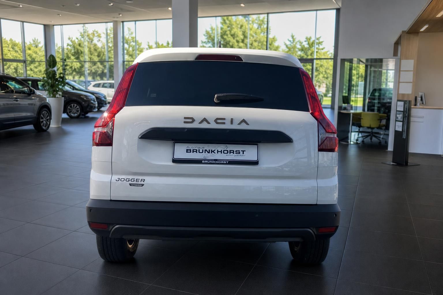 Dacia Jogger Hybrid Heckansicht in weiß - Rücklichter und Brunkhorst Kennzeichen im Autohaus