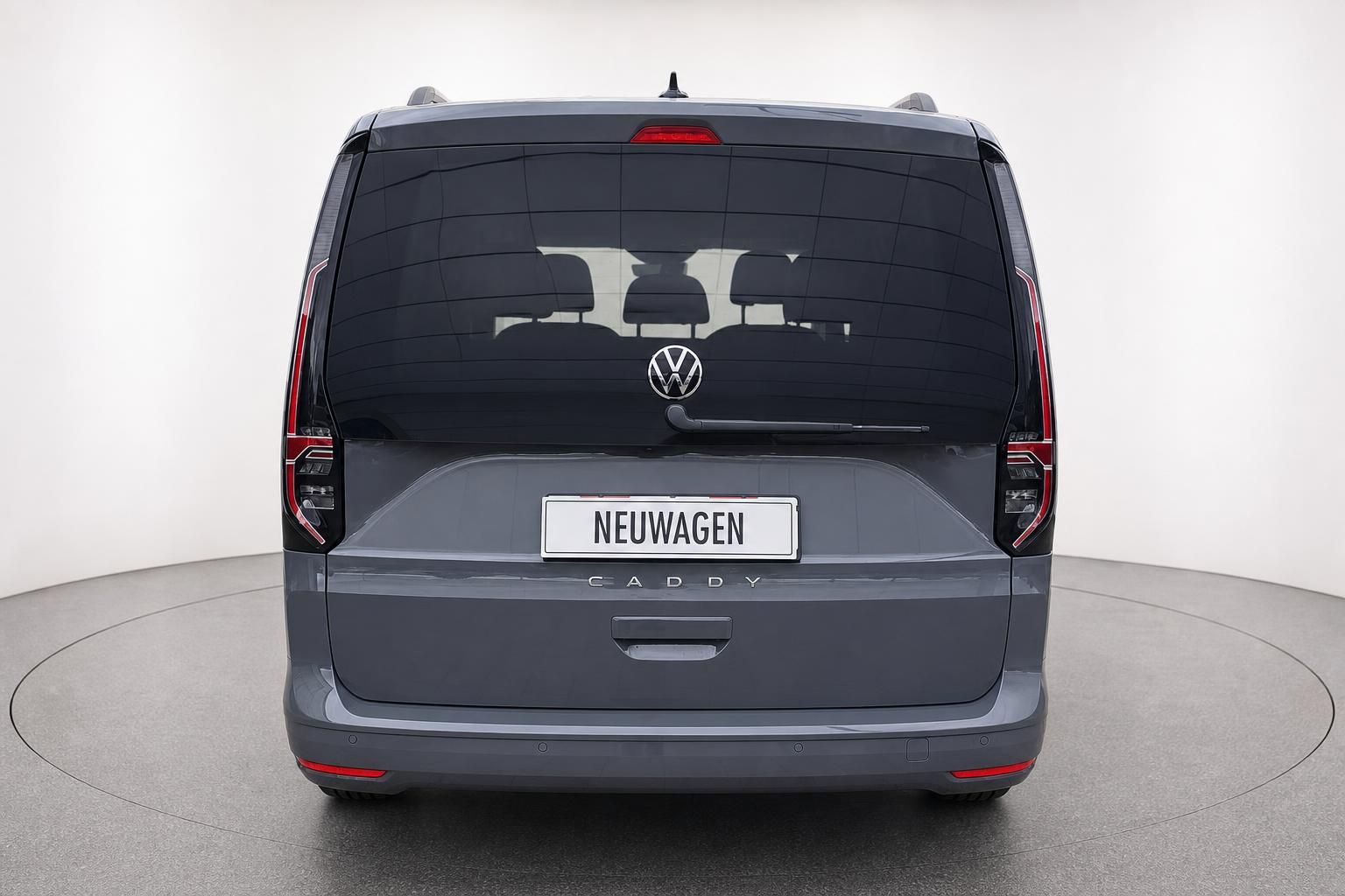 VW Caddy Neuwagen in Grau, Heckansicht mit Rueckleuchten im Studio