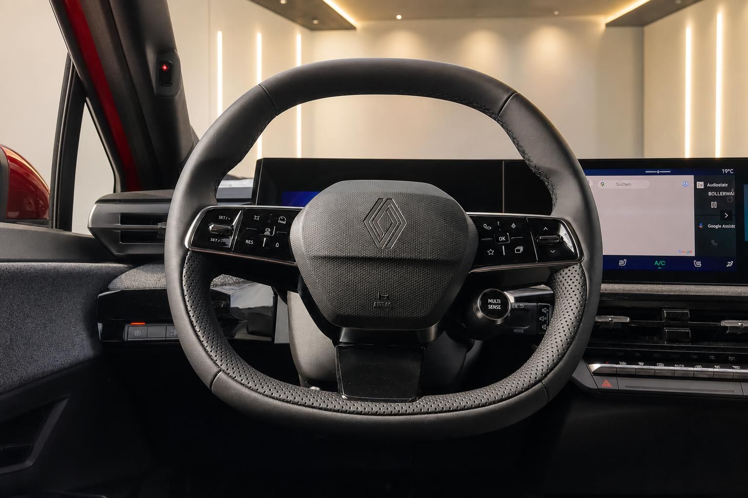 Lenkrad mit Multifunktionstasten und Digitaldisplay im Fahrzeuginnenraum