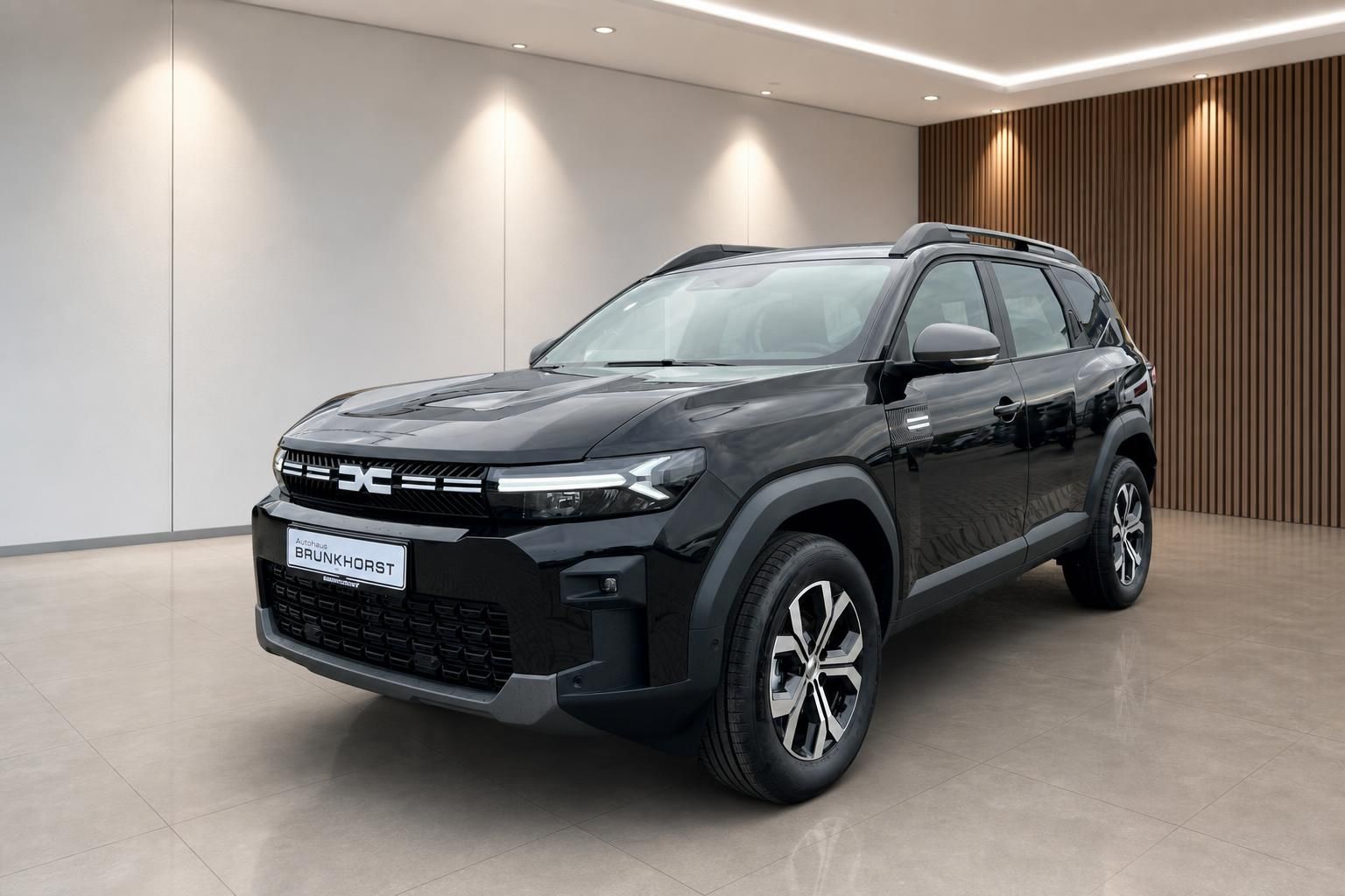 Dacia Bigster SUV in Anthrazit im modernen Showroom - seitliche Frontansicht