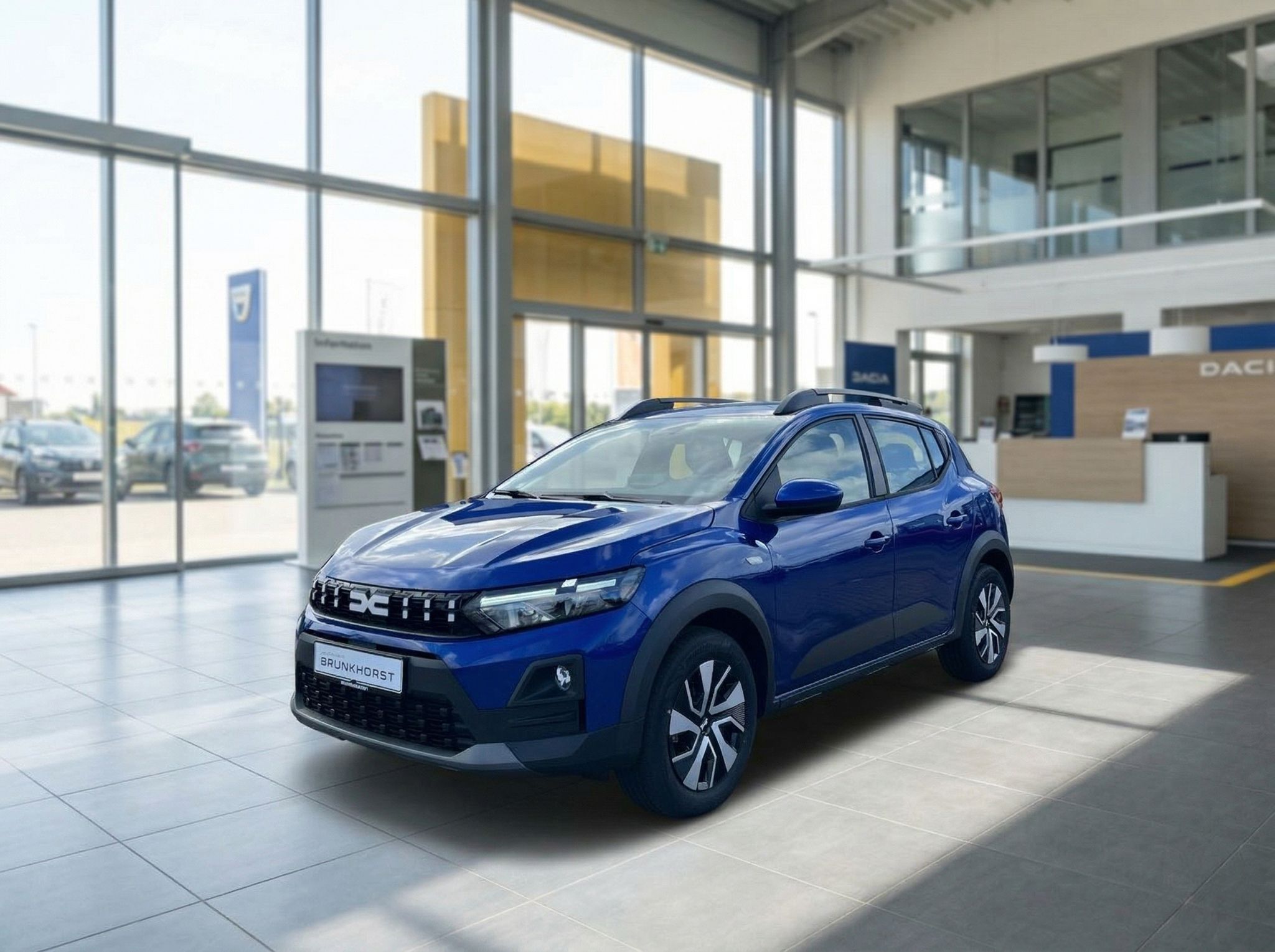 Blauer Dacia Sandero SUV in modernem Autohaus-Showroom mit großen Fenstern