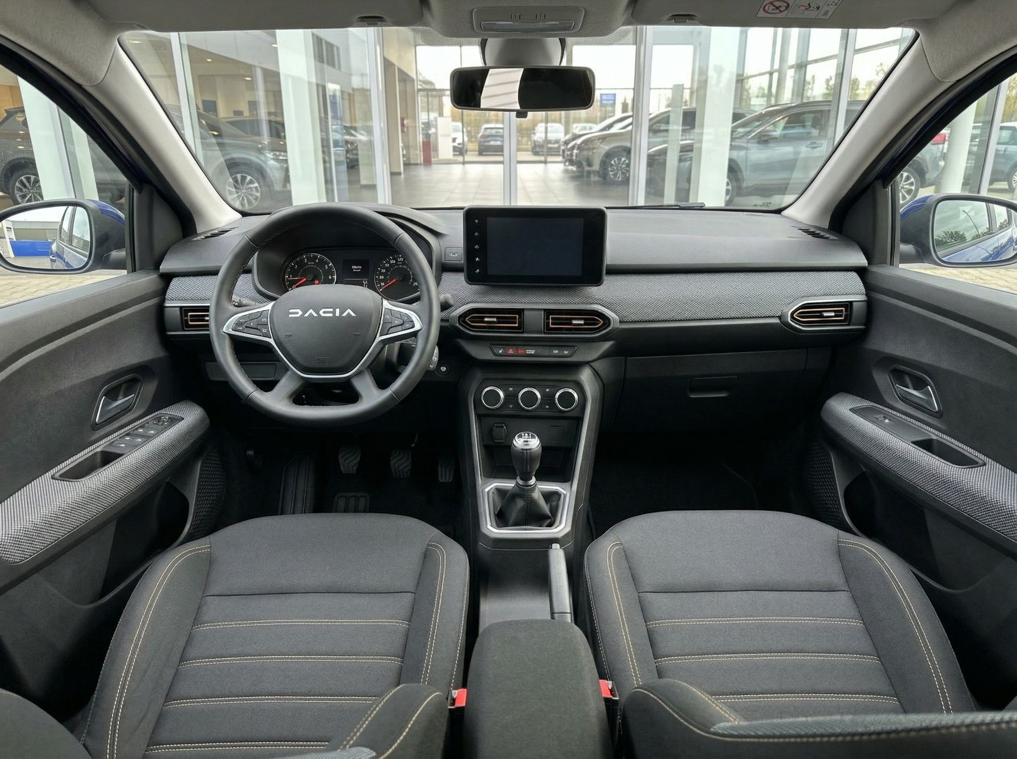 Dacia Fahrzeug Innenraum mit Lenkrad, Armaturenbrett und grauem Interieur