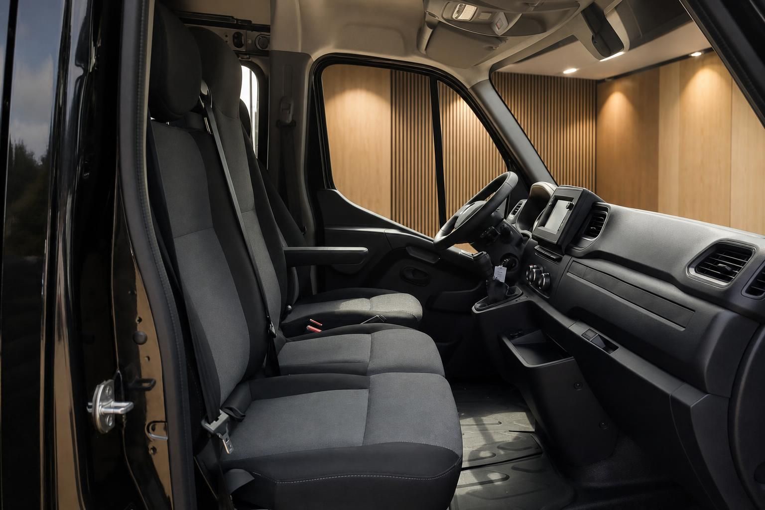 Renault Master Innenraum – Fahrerhaus mit Sitzen, Armaturenbrett und Holzverkleidung im Laderaum