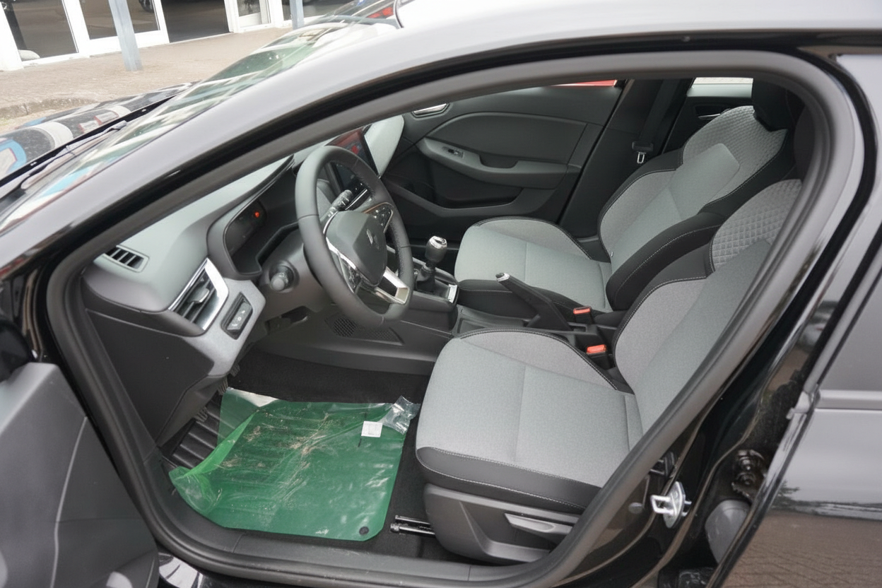 Fahrzeug Innenraum mit grau-schwarzen Stoffsitzen, Lenkrad und Mittelkonsole