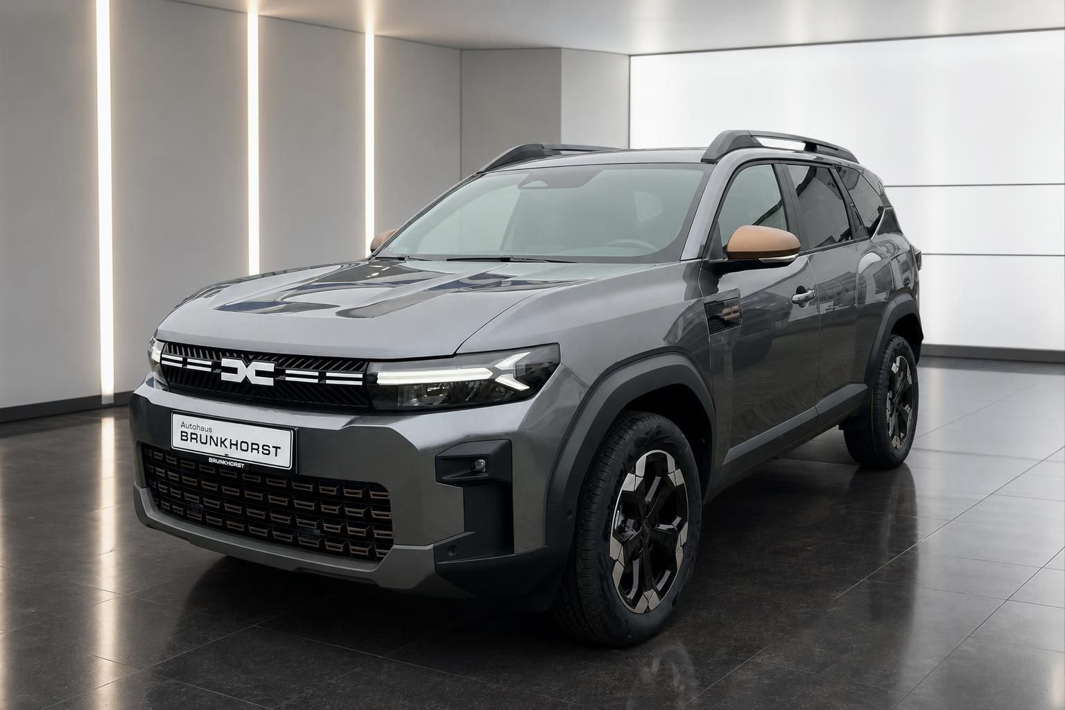 Dacia Bigster SUV Seitenansicht in grau mit Dachträgern im Autohaus