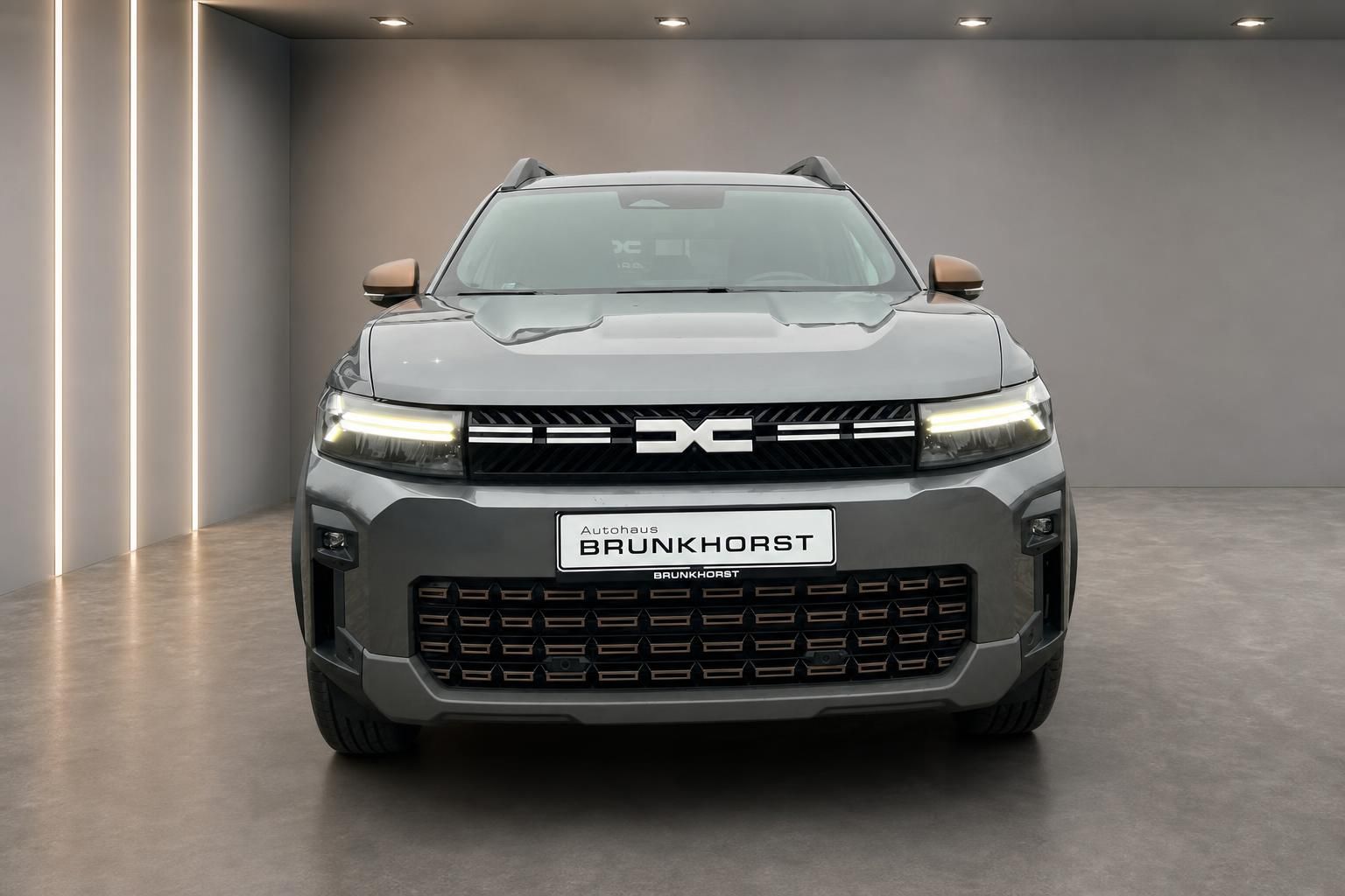 Dacia Bigster SUV Frontansicht in grau mit LED-Scheinwerfern im Showroom