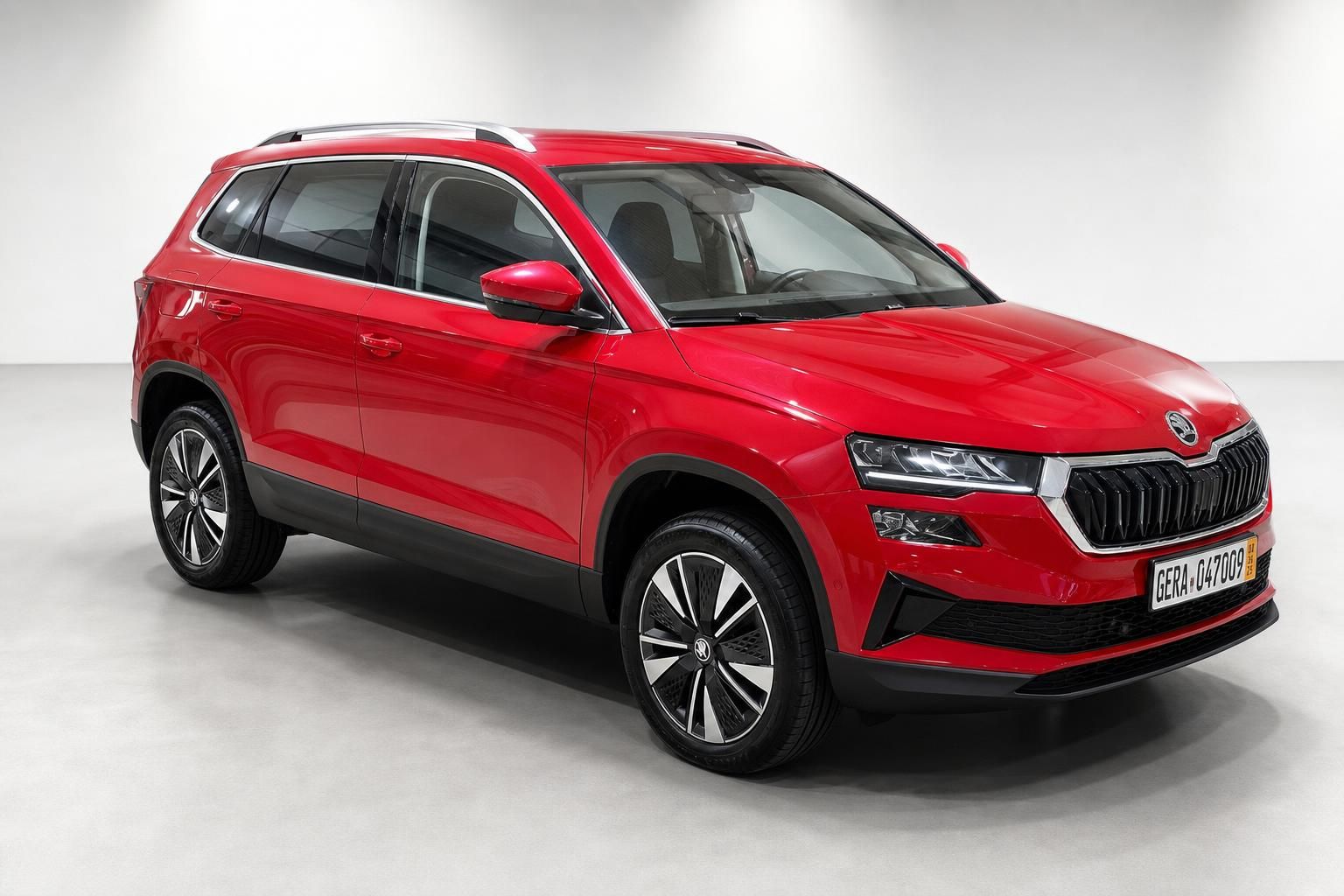 Roter Skoda Karoq SUV Seitenansicht schräg vorne im Fotostudio