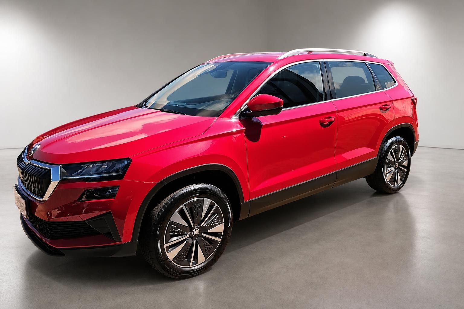 Roter Skoda Karoq SUV schräge Frontansicht mit Alufelgen im Studio