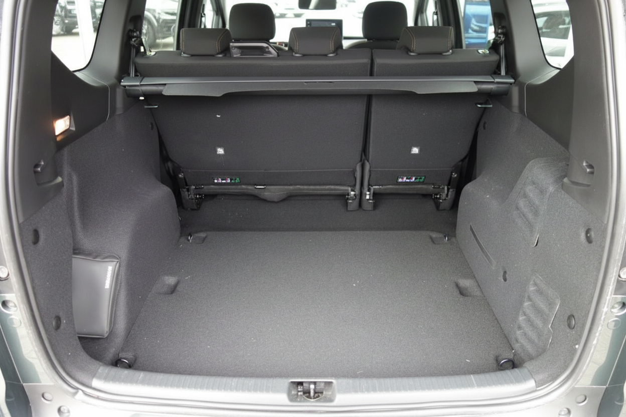 Geräumiger Kofferraum eines Kompakt-SUV mit umgeklappten Rücksitzen und grauem Teppichboden