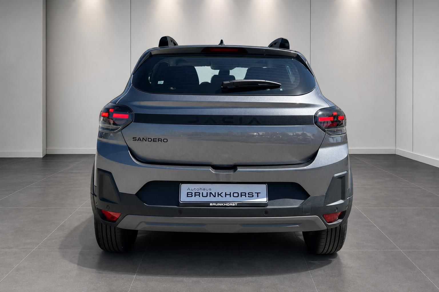 Dacia Sandero Heckansicht in grau metallic im Autohaus-Showroom
