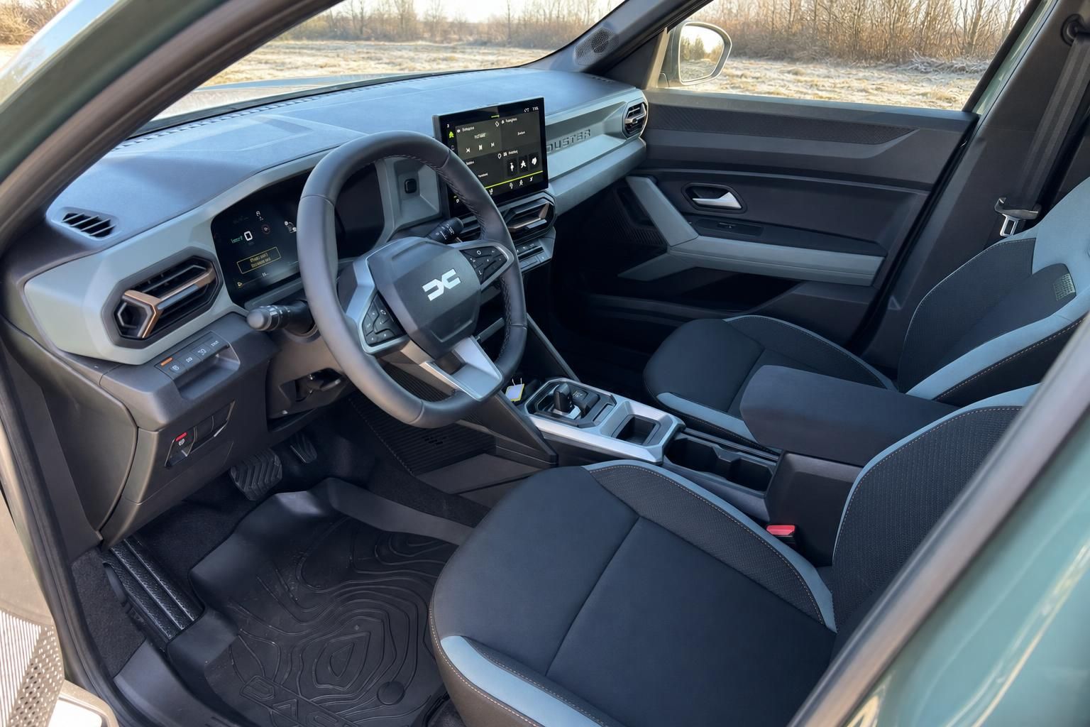 Dacia Duster Innenraum mit schwarzen Sitzen, Touchscreen und modernem Cockpit