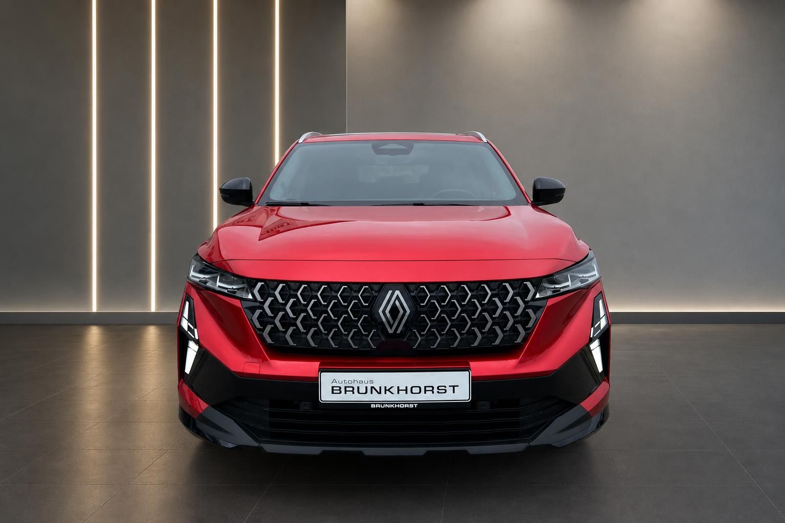 Roter Renault Frontansicht mit charakteristischem Kühlergrill im modernen Showroom