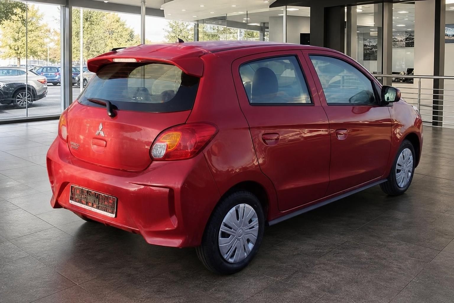 Roter Mitsubishi Space Star Schrägansicht hinten im Autohaus Showroom