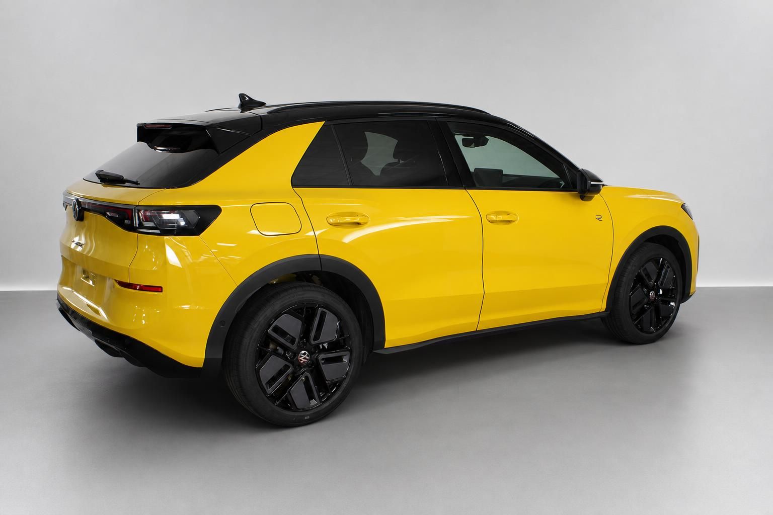 VW T-Roc gelb, Heckansicht seitlich im Studio