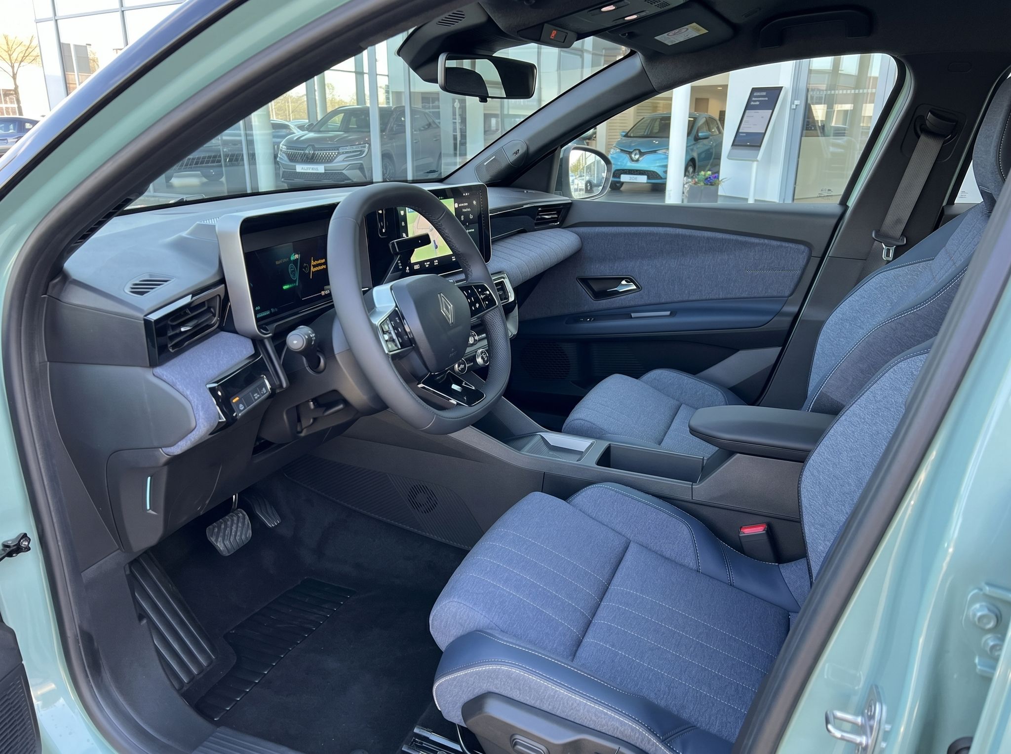 Renault 4 E-Tech Innenraum mit modernem Dashboard und blauen Stoffsitzen