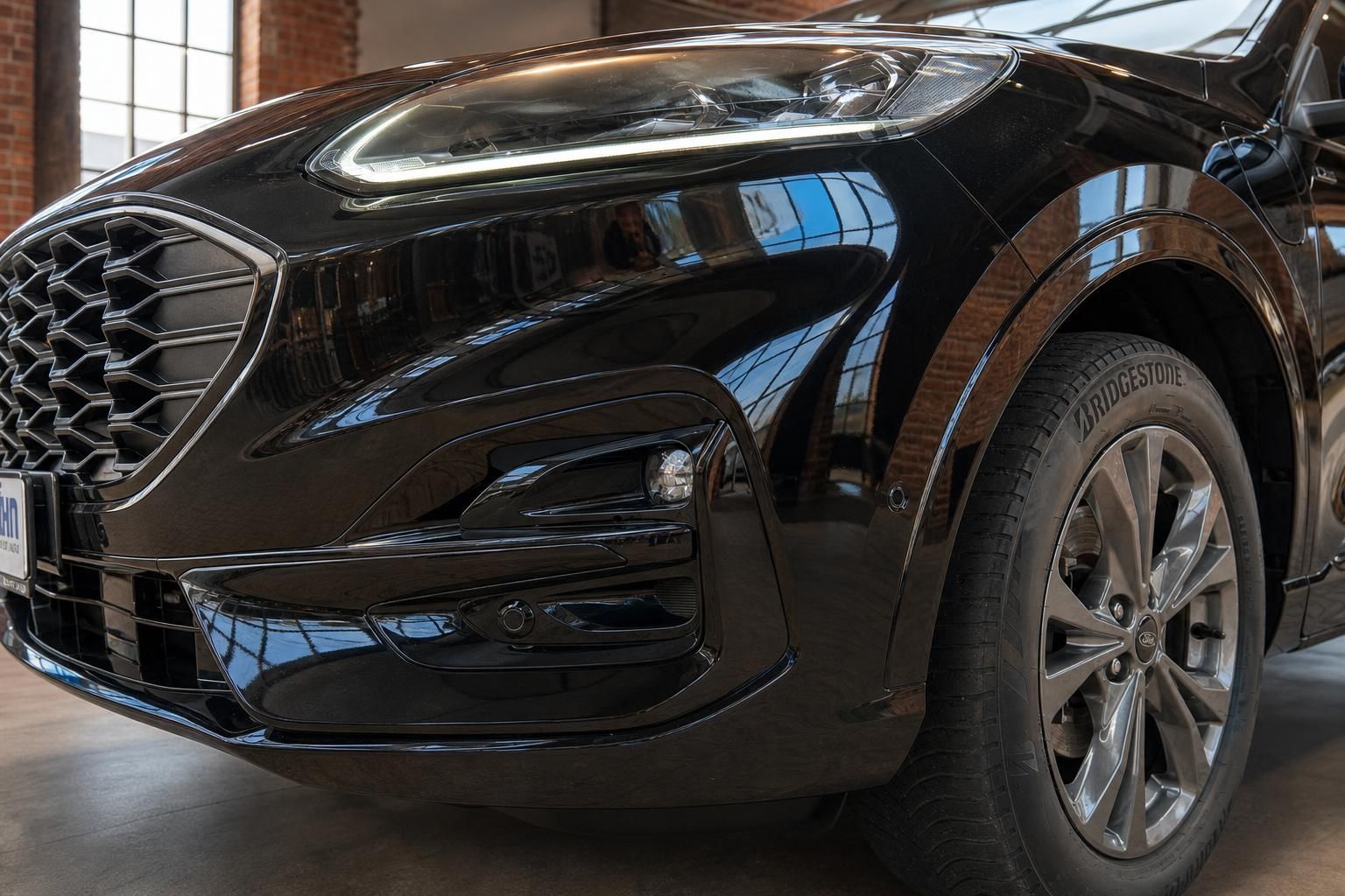 Ford Kuga schwarz Detail Frontstoßstange und Scheinwerfer Nahaufnahme