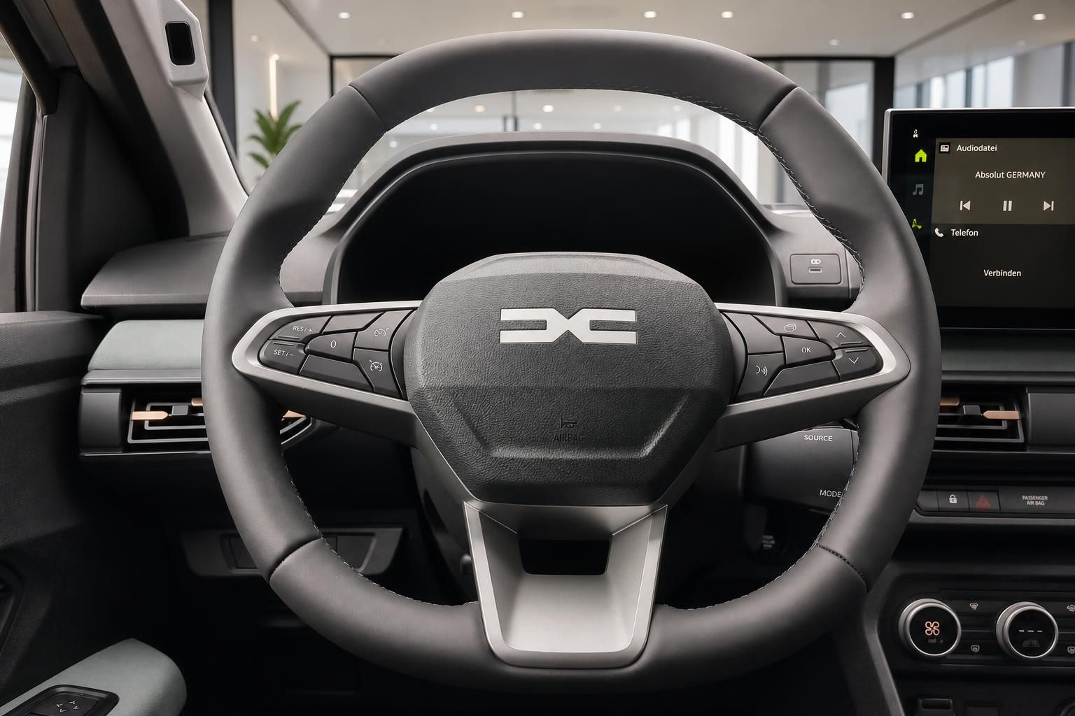 Lenkrad mit Multifunktionstasten und Infotainment-Display im Fahrzeug