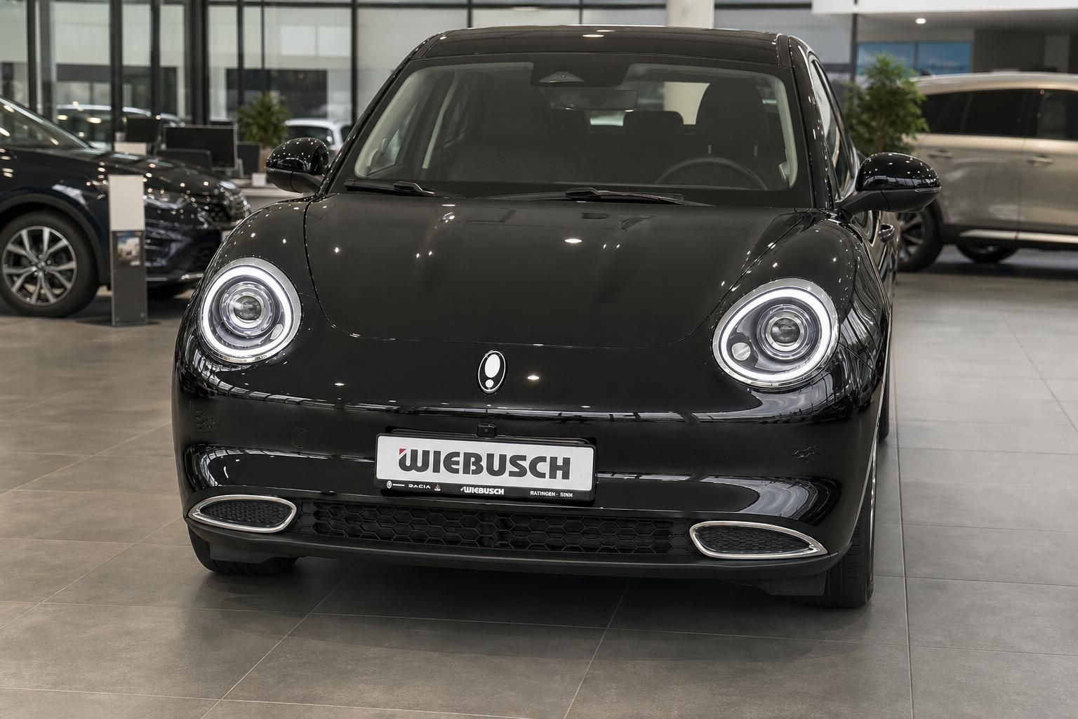 Schwarzer Elektro-Kleinwagen im Autohaus-Showroom, Frontansicht mit charakteristischen LED-Scheinwerfern