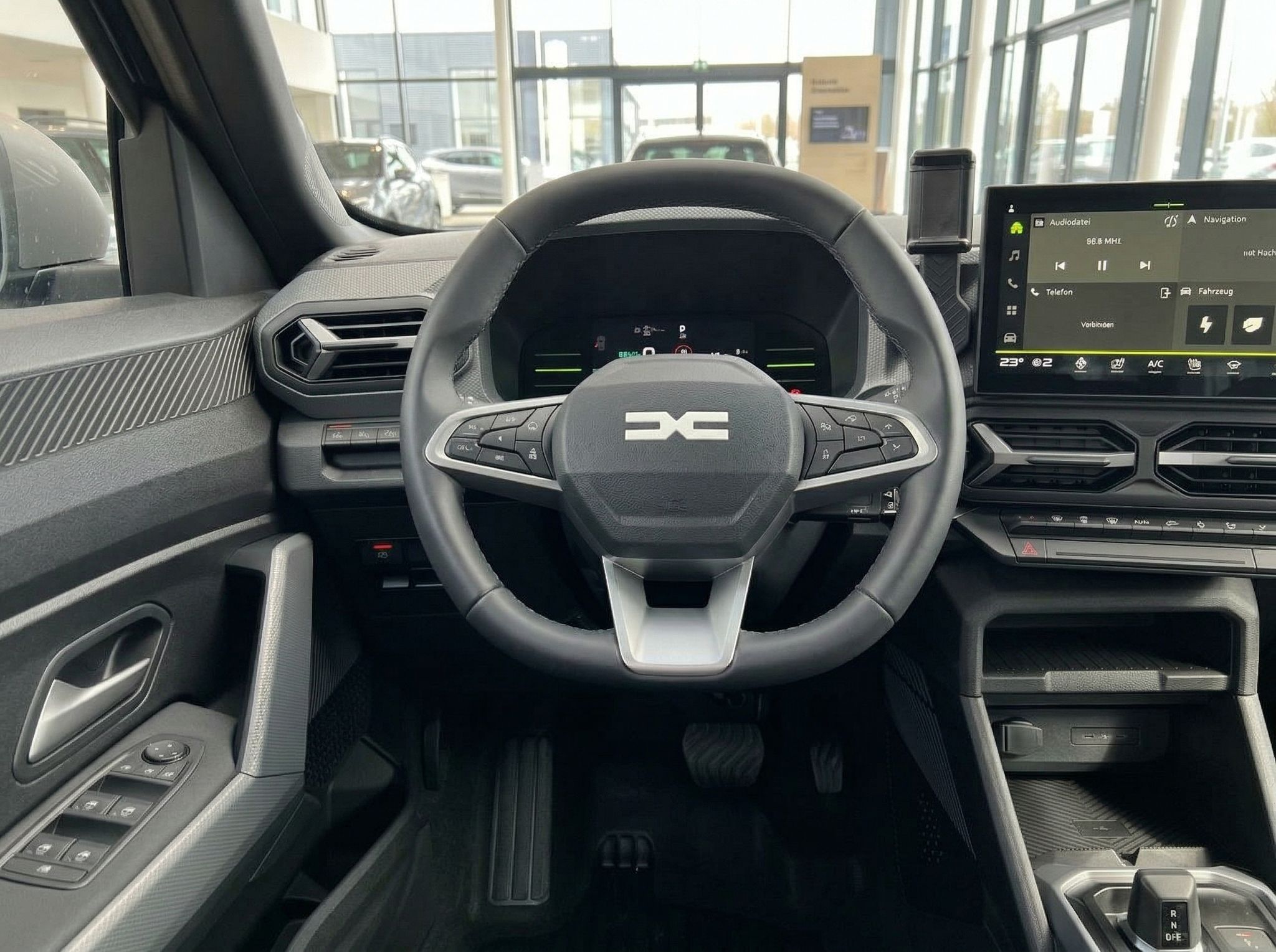 Detailansicht des Lenkrads mit DC-Logo und digitalem Kombiinstrument im Fahrzeuginnenraum