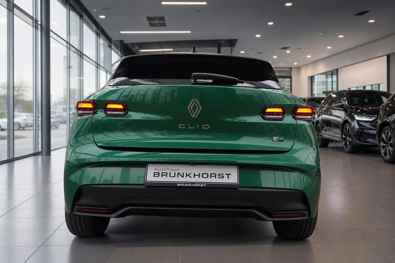 Grüner Renault Clio Elektro Heckansicht mit LED-Rückleuchten im Autohaus Showroom