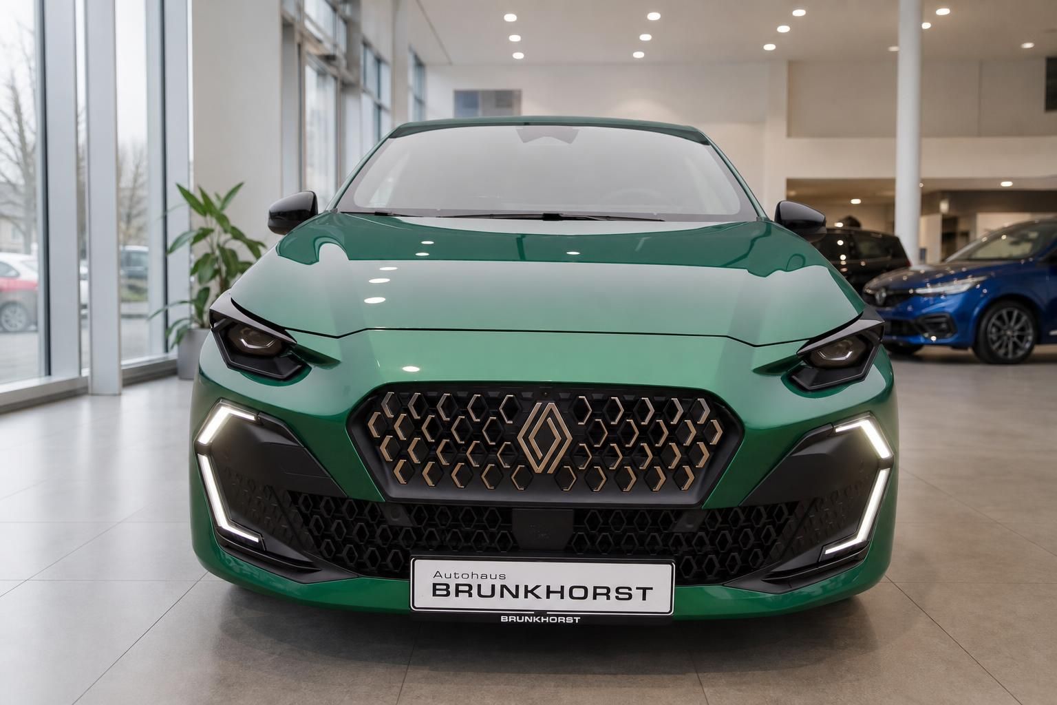 Grüner Renault Clio Frontansicht mit LED-Scheinwerfern und Wabengrilldesign im Autohaus
