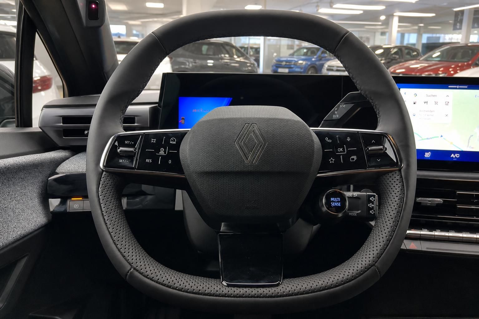 Renault Lenkrad mit Logo, Bedientasten und digitalem Instrumentencluster dahinter