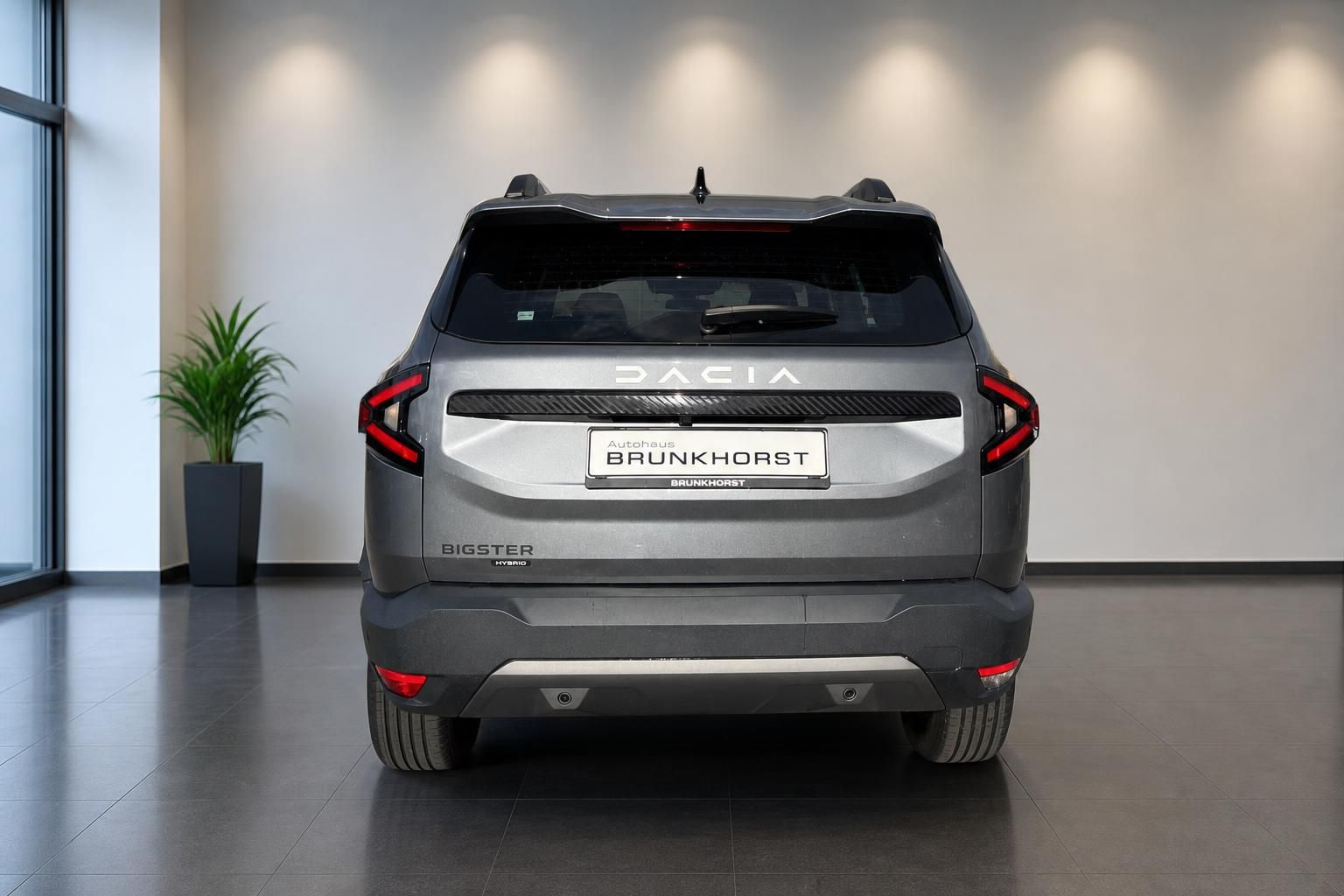 Dacia Bigster Hybrid Heckansicht in grau im Showroom - modernes SUV mit LED-Rückleuchten