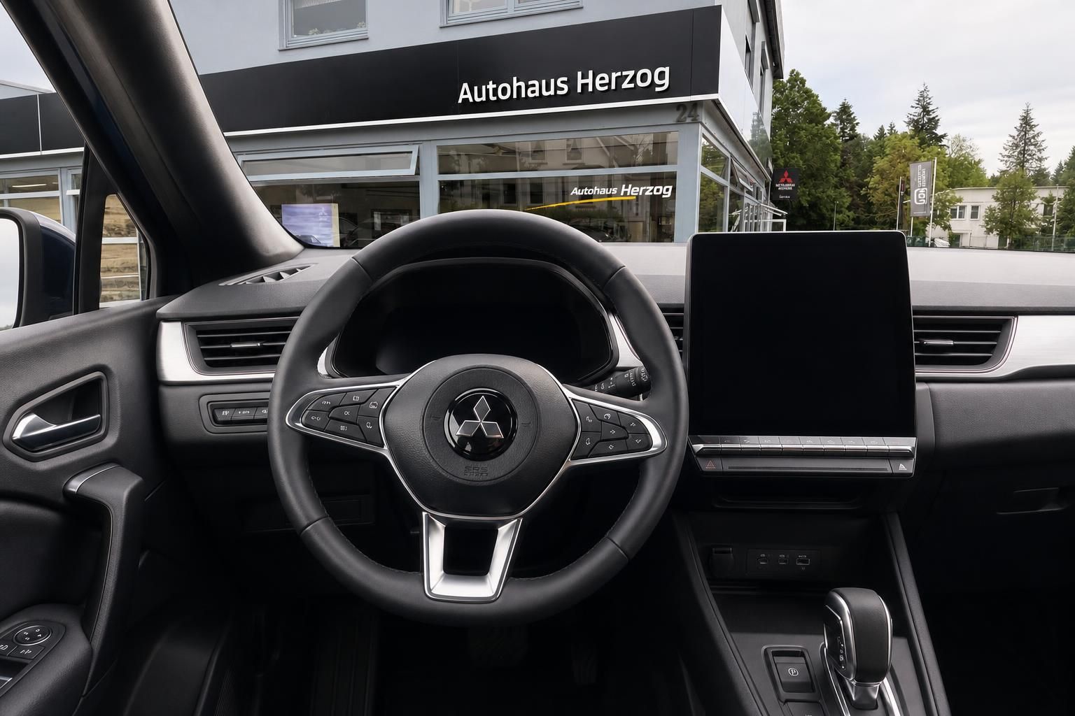 Mitsubishi Innenraum mit Lenkrad, Touchscreen und modernem Cockpit - Fahrerperspektive