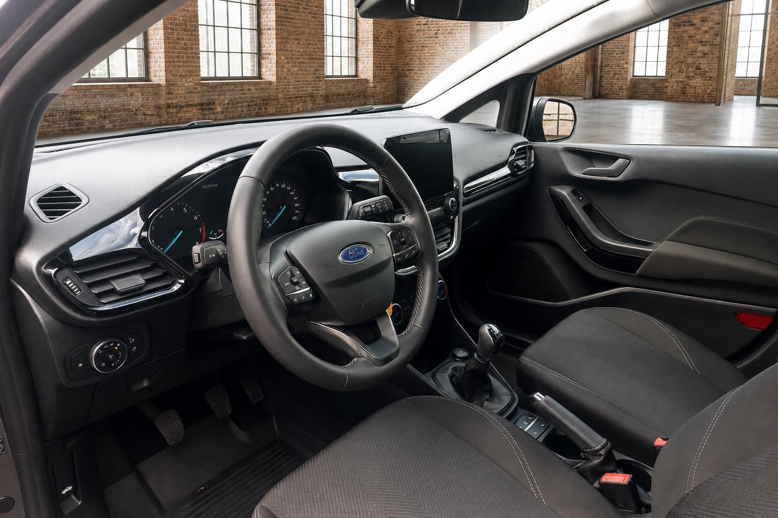 Ford Fiesta Innenraum – Cockpit mit Lenkrad, Infotainment und schwarzen Stoffsitzen
