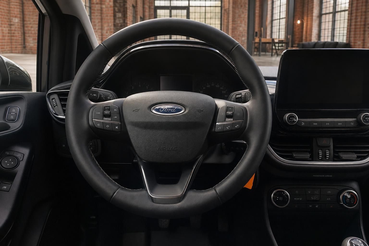 Ford Fiesta Lenkrad Nahaufnahme mit Multifunktionstasten und Touchscreen im Hintergrund
