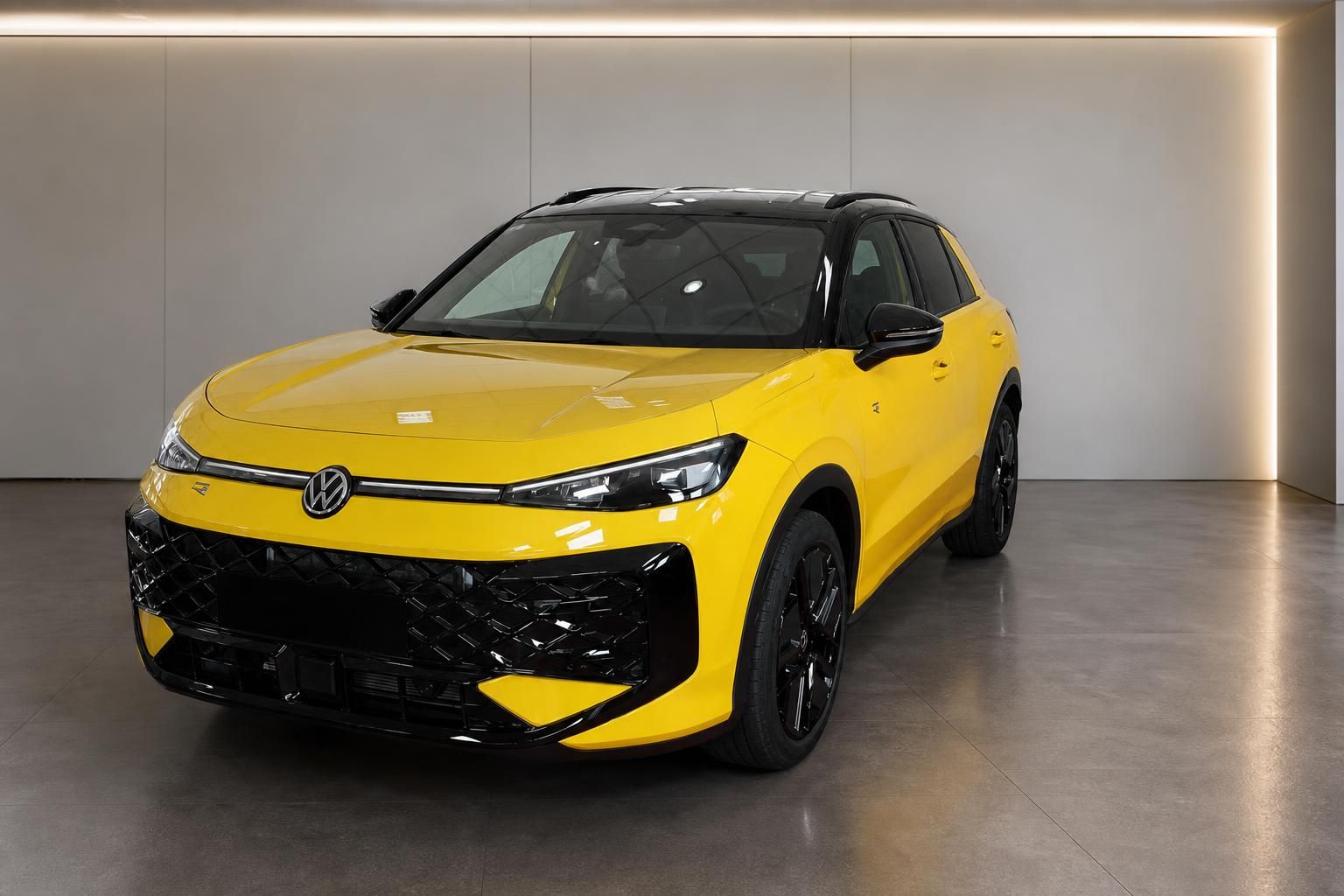 VW T-Roc in Gelb mit schwarzem Dach, Frontansicht im Autohaus