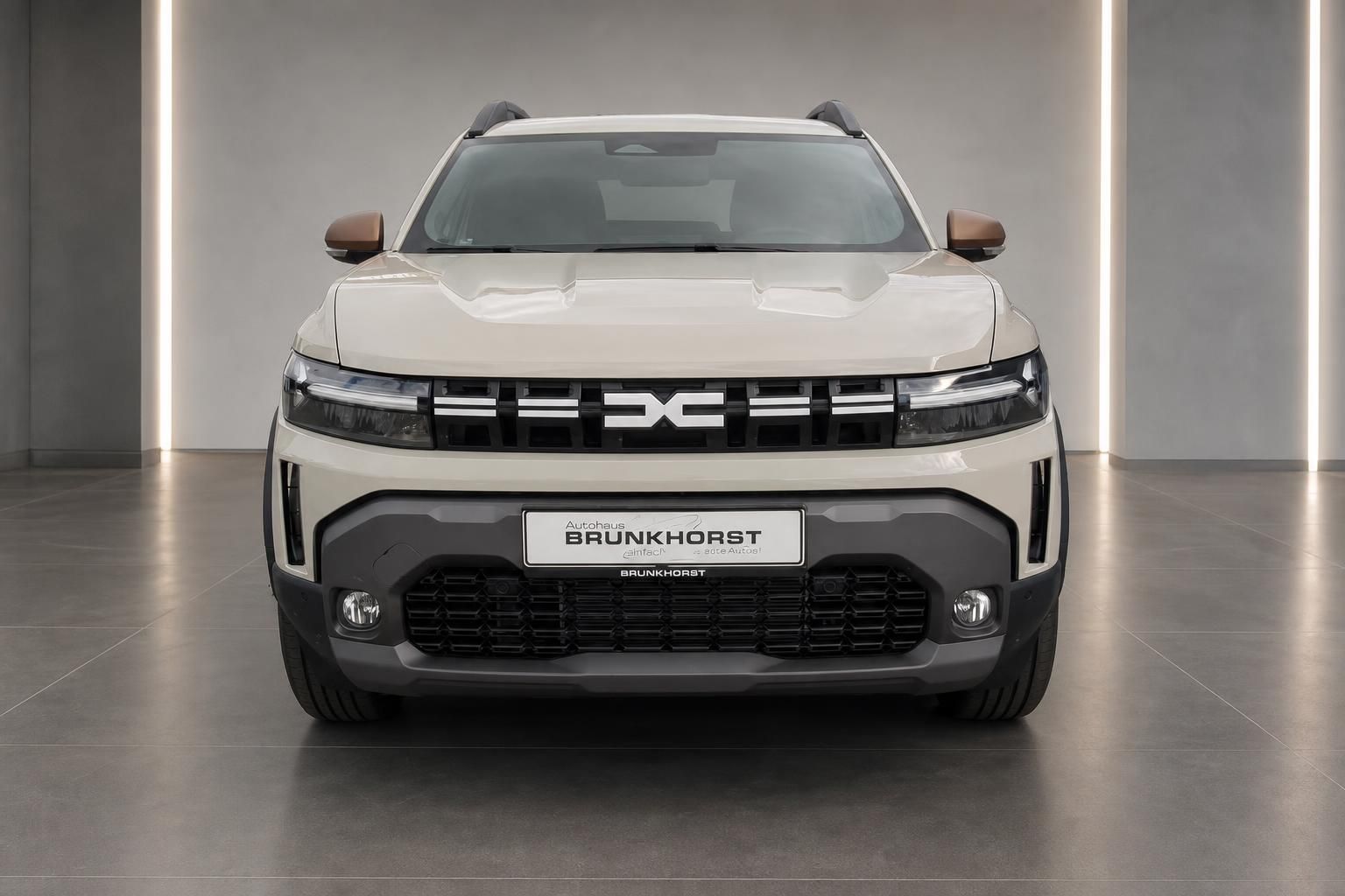 Dacia Duster beige, Frontansicht mit Kuehlergrill im Showroom