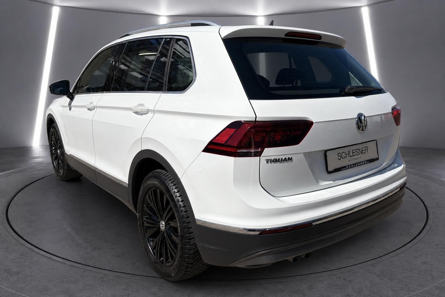 VW Tiguan weiß Heckansicht schräg auf Drehteller im Showroom